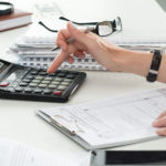 Close up of female accountant or banker making calculations.