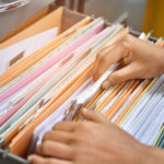 Woman going through files in a filing cabinet