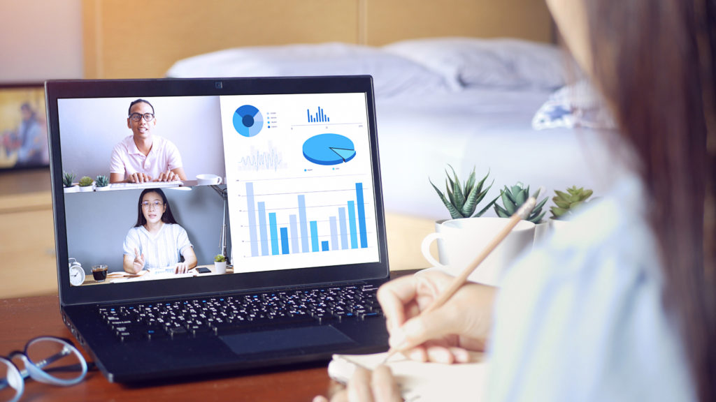 A woman participates in a meeting with colleagues from her laptop at home.