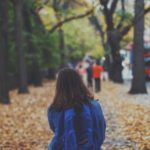 Young girl with a blue backpack walking to school